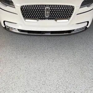 White Lincoln sedan parked on a gray full-flake epoxy and polyaspartic-coated garage floor.